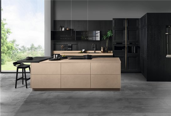 Inselküche in sandfarbener Betonoptik mit schwarzen Fronten aus Holzfurnier