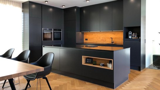 Inselküche in anthrazit/dunkelgrau mit Holzdetails