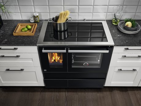 Küchenzeile in weißer Landhausküche mit modernem Holzherd in schwarz