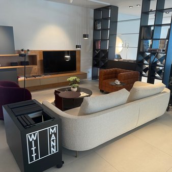 Modernes Wohnzimmer mit hellgrauer Couch und einer Wohnwand aus Holz