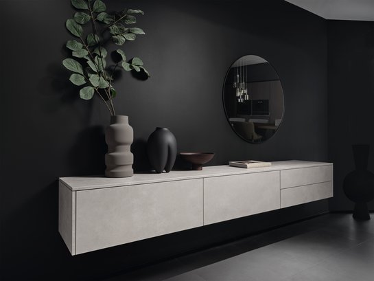 Graues Sideboard auf schwarzer Wand mit Dekoration