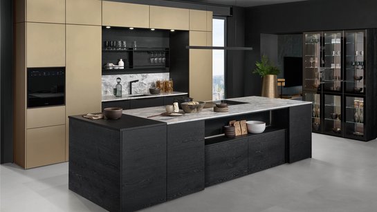 Inselküche mit schwarzer Holz-Kücheninsel und bronzefarbigen Hochschränken