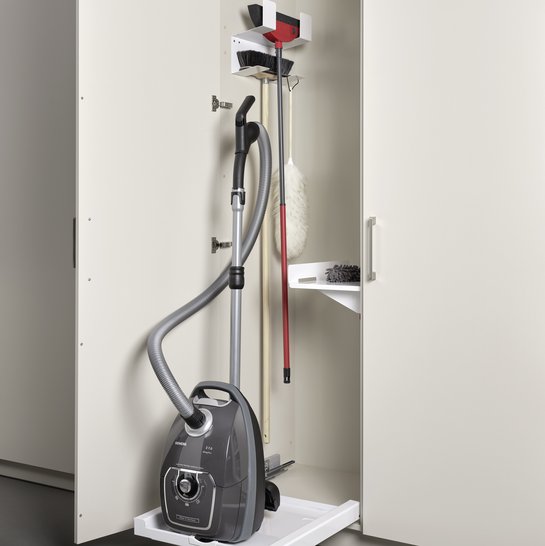 Ein Hochschrank mit einem Auszug für den Staubsauger und einem Besenhalter.