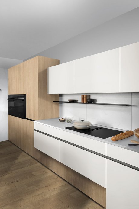 Küchenzeile mit weißen Fronten, Aluminium-Griffleisten und Holzdetails.