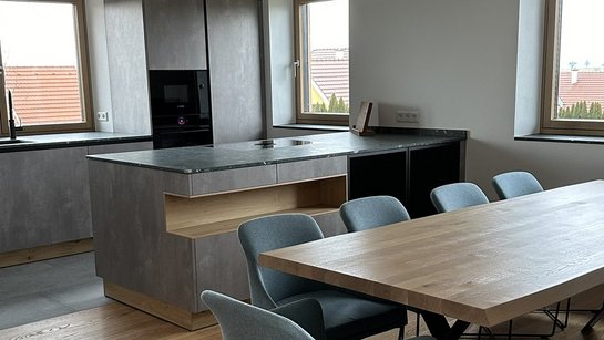 Graue Küche mit dunklen Parsolglas-Glastürschränken und Nischenregal in der Kücheninsel