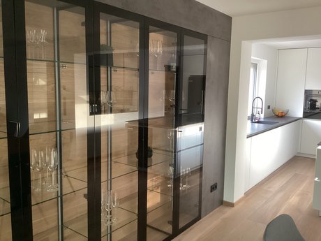 Offene Eleganz: Die Glasvitrine lockert die Wandfläche stilvoll auf.